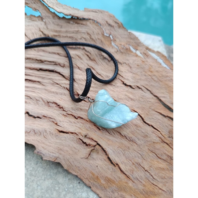 vue de détail du pendentif en aigue marine brute sur support bois, couleurs et texture naturelles
