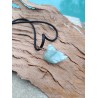 vue de détail du pendentif en aigue marine brute sur support bois, couleurs et texture naturelles